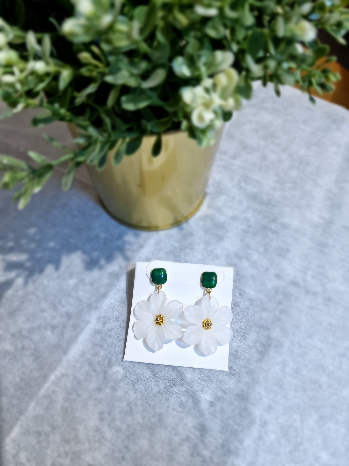 Pendientes de flor de camelia blanca, con aretes verdes.