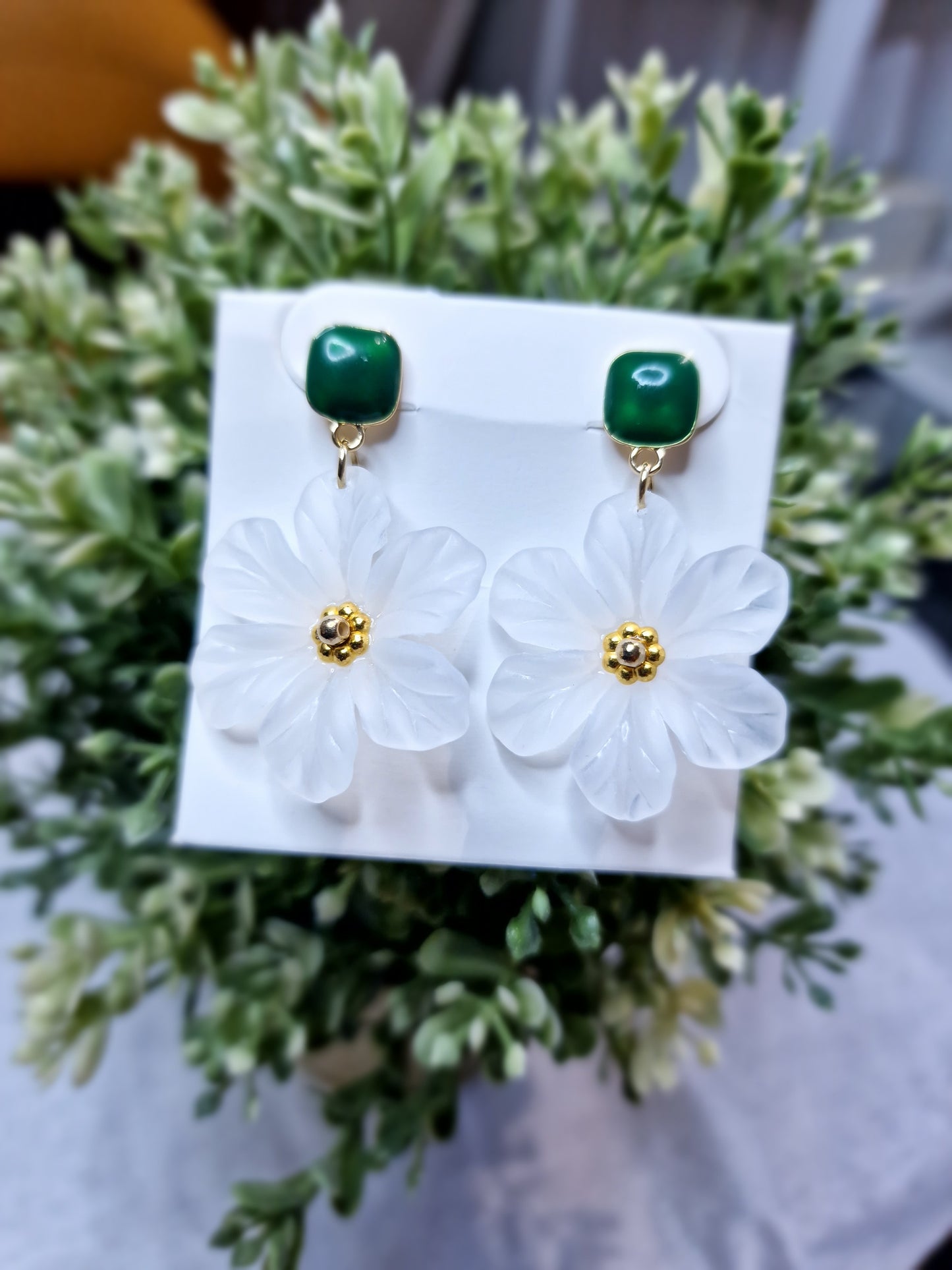 Pendientes de flor de camelia blanca, con aretes verdes.