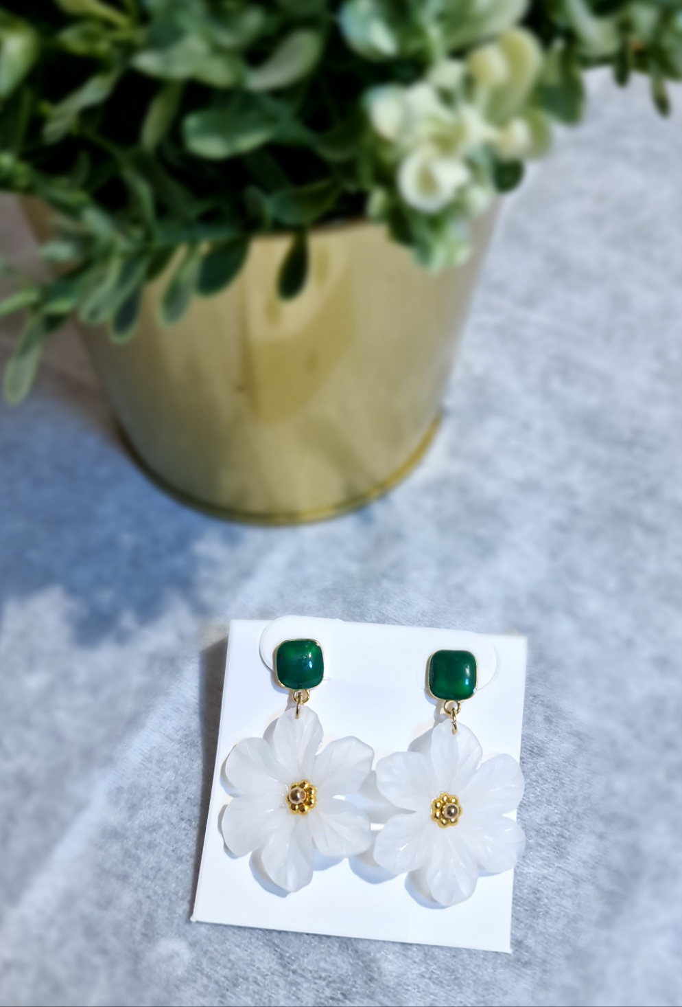 Pendientes de flor de camelia blanca, con aretes verdes.