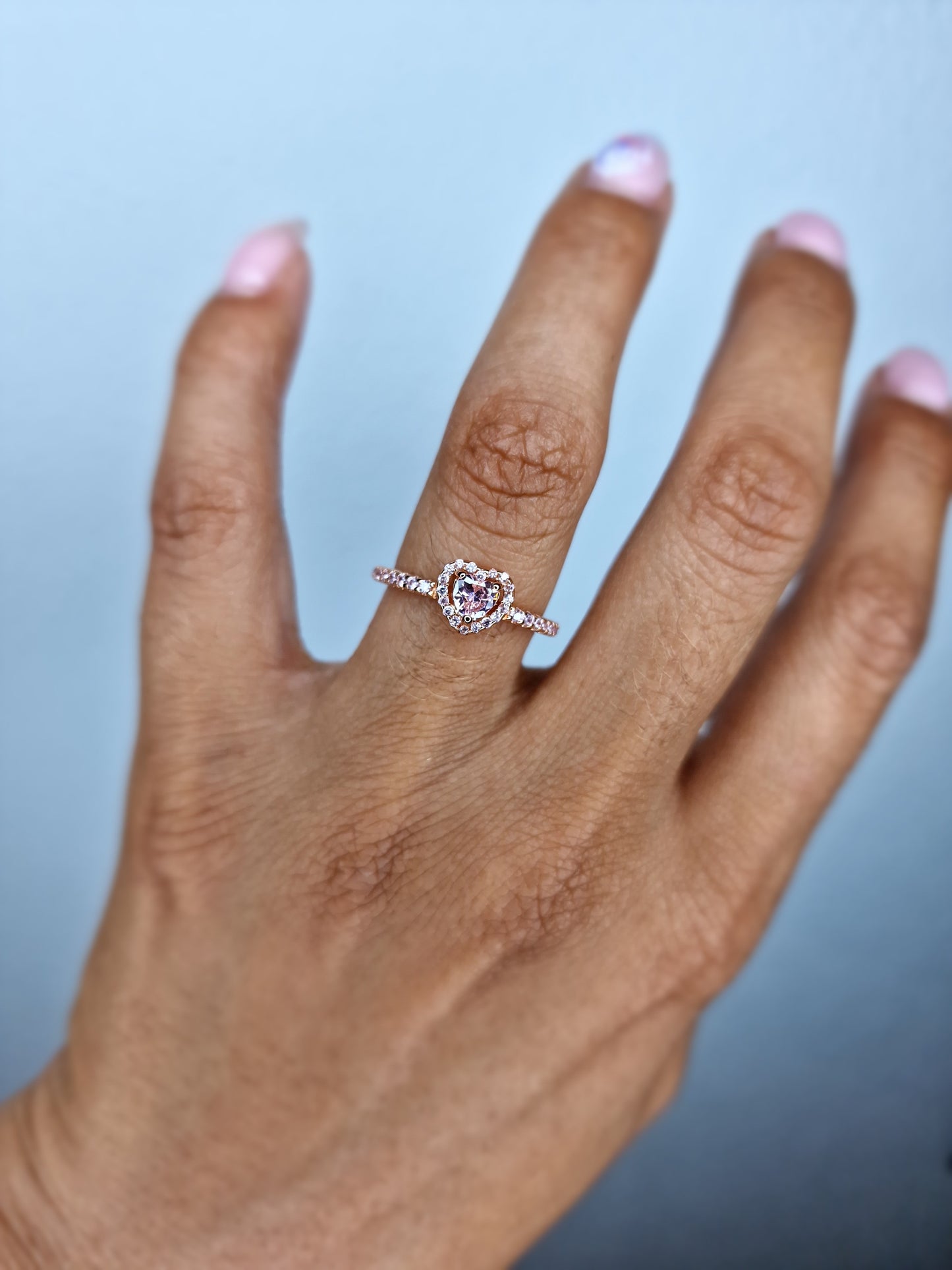 Anillo dorado con corazón rosado.