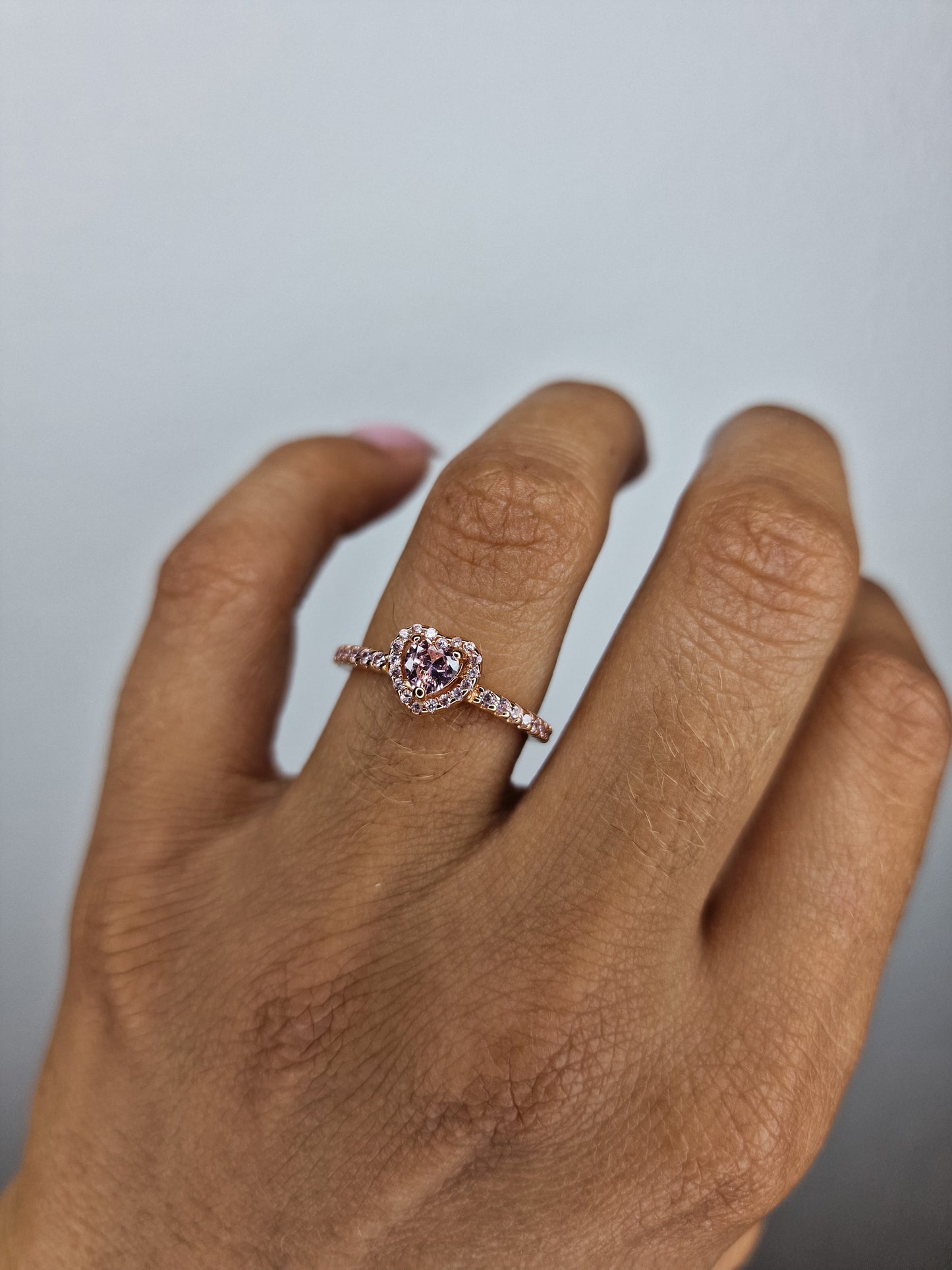 Anillo dorado con corazón rosado.